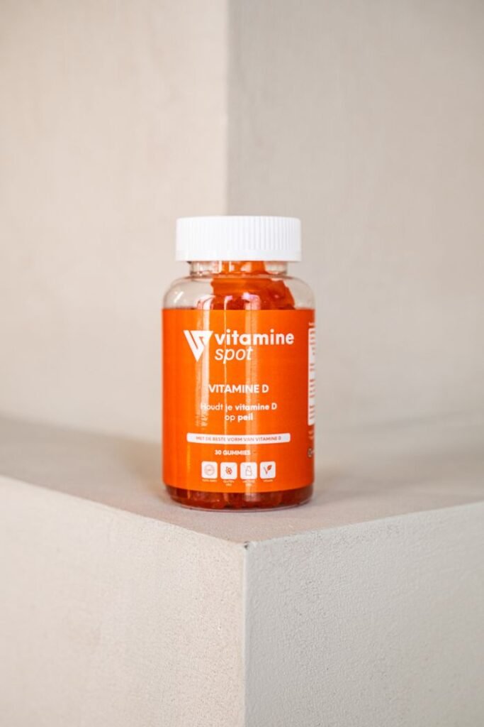Close-up of a vitamin D supplement bottle by Vitamine Spot on a minimalist concrete surface.