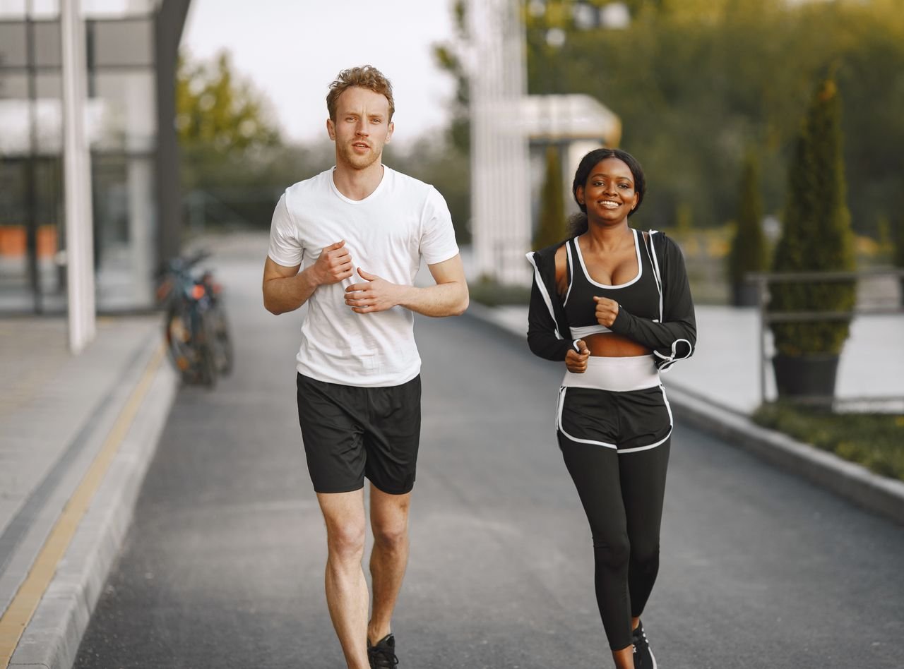 A man and woman jogging together outside, embracing a healthy lifestyle.