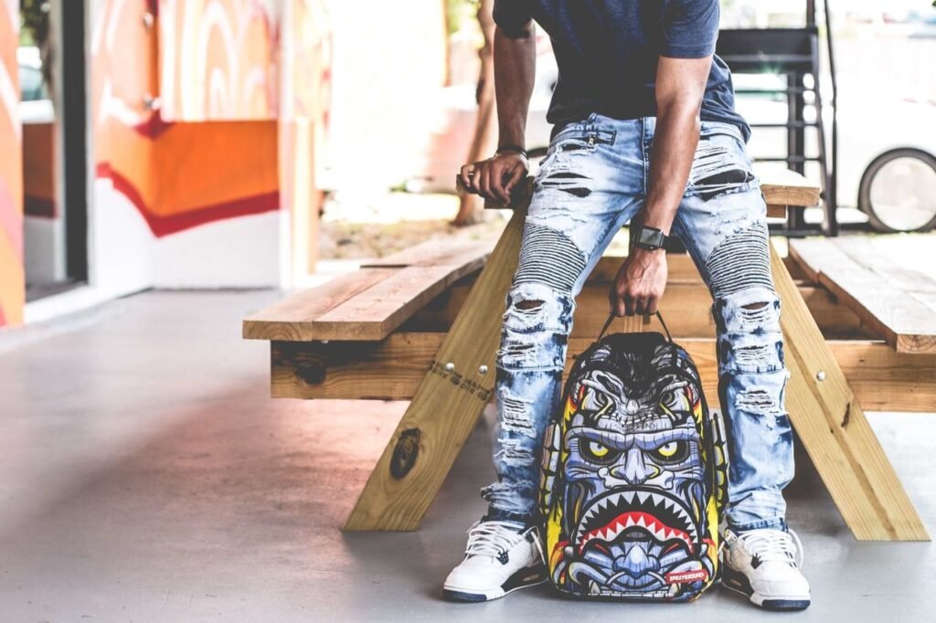 Find Your Perfect Match Edgy urban fashion photoshoot featuring ripped jeans and a bold graphic backpack.